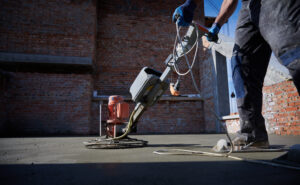 Leveling concrete being shown by a man standing on concrete.