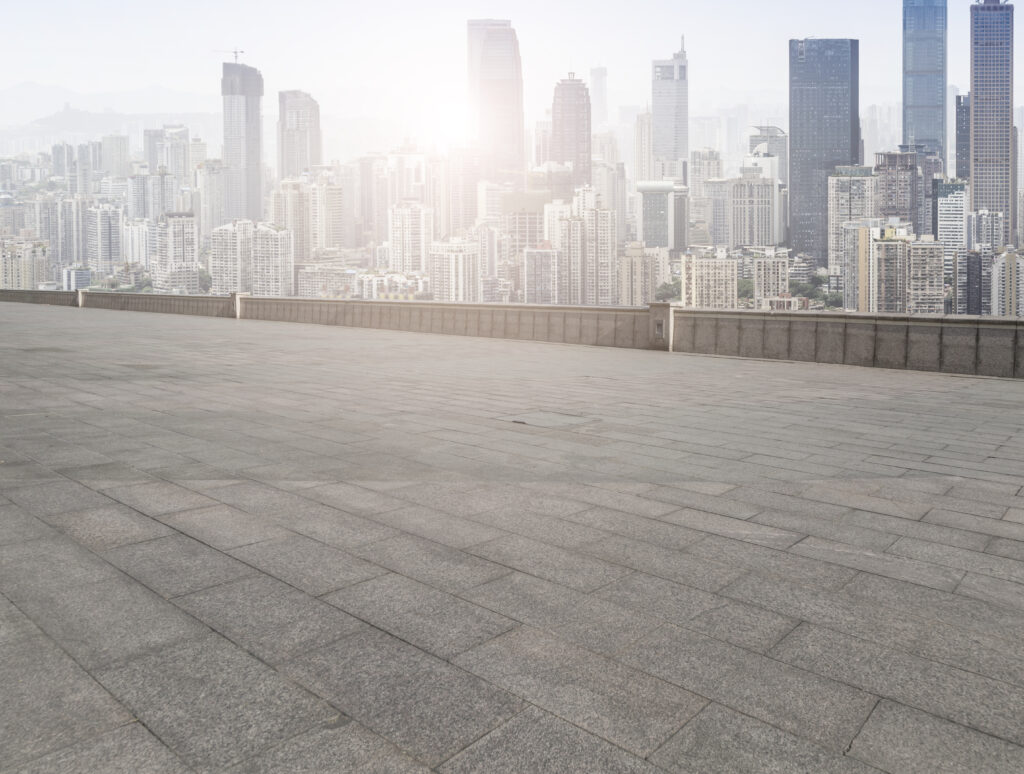 How to level a concrete floor that slopes: A large open area shows a concrete floor and greenery on the far front.