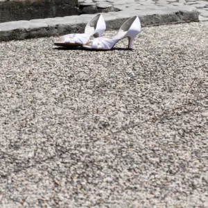 A pair of white heels on a newly mudjacked concrete