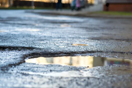 Commercial Concrete Repair Contractors - Potholes Filled with Water in an Asphalt Parking Lot
