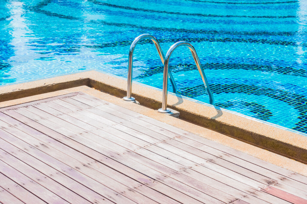 A pool deck with clean blue water.