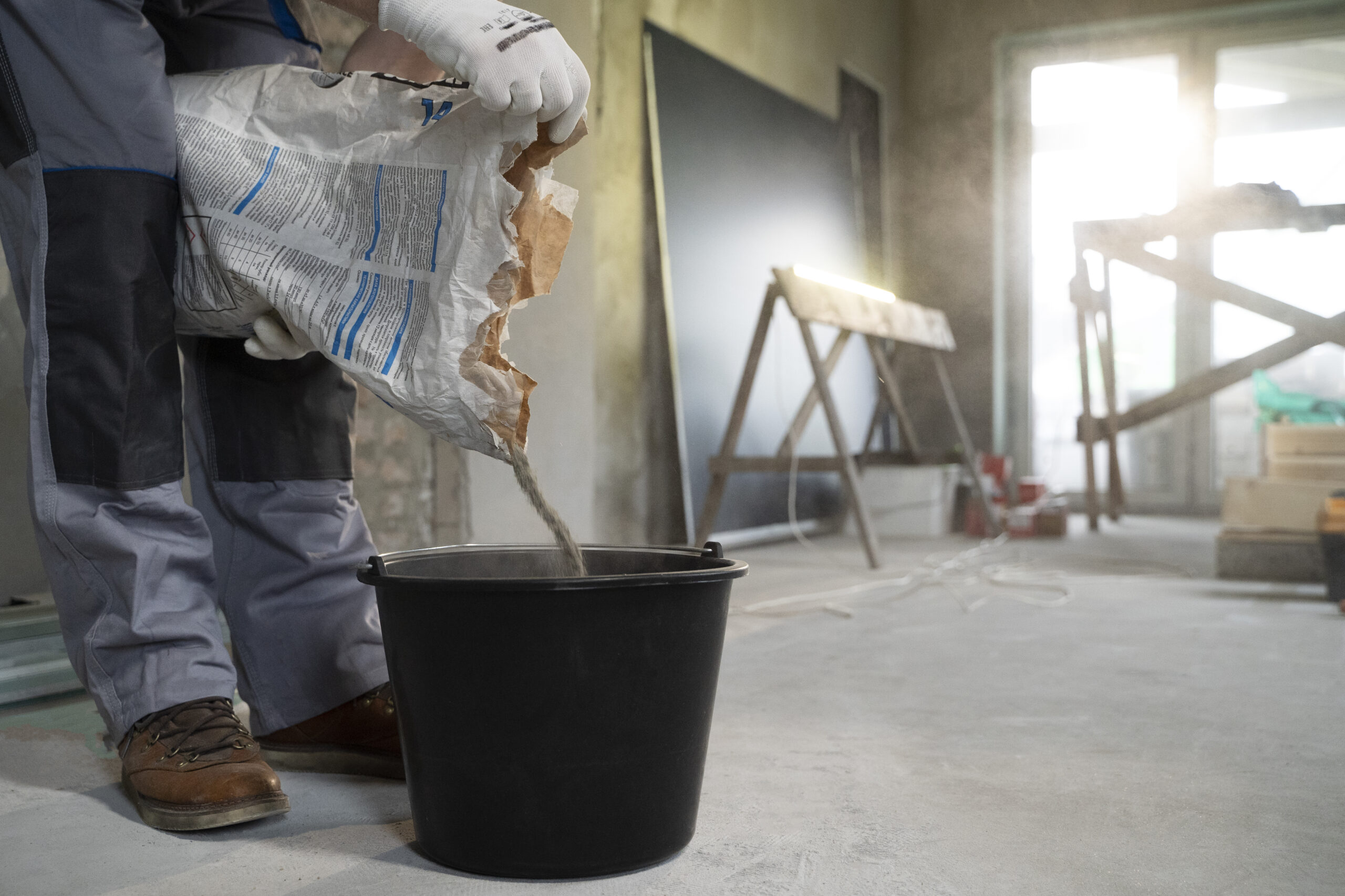 A contractor mixing sealing solution before getting to seal a driveway in Queens