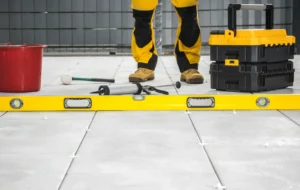 Commercial Floor Leveling and Restoration – A Contractor Standing on a Commercial Floor with His Tools in Front of Him