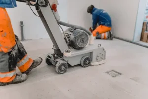 A contractor using the concrete grinding machine on the concrete surface.