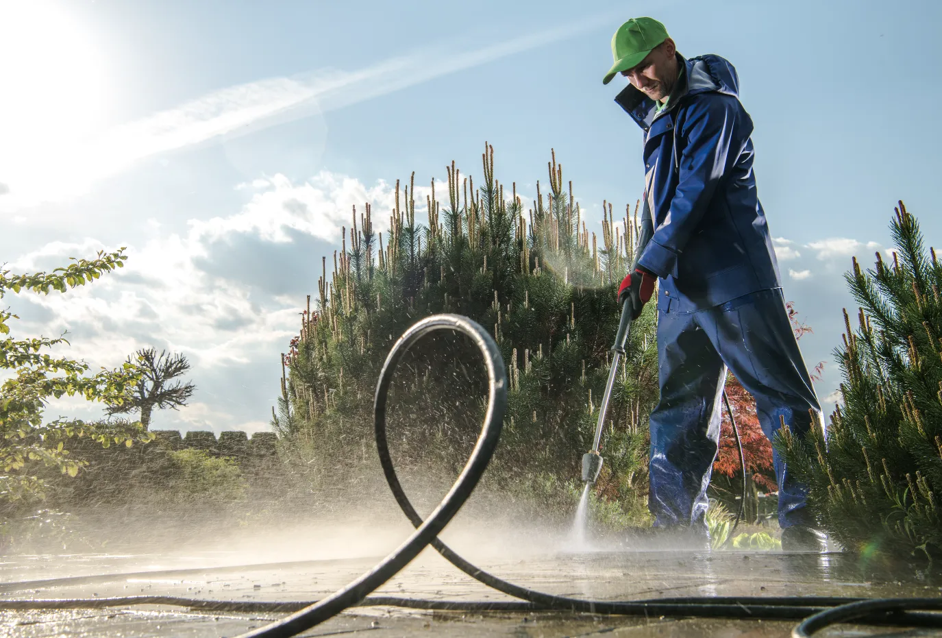 How to Clean Up Calcium Chloride Brine from Concrete - A Man Pressure Washing a Driveway