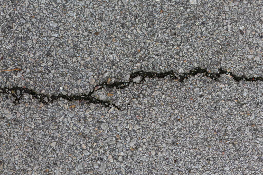 Cracked concrete surface with rocks