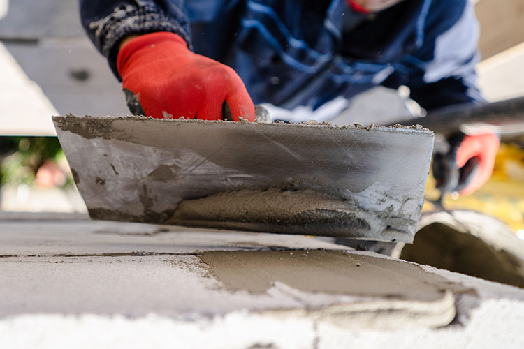 Closeup shot of man smoothing out wet concrete