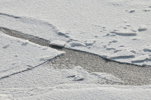 Cracked ice on concrete surface in the sun