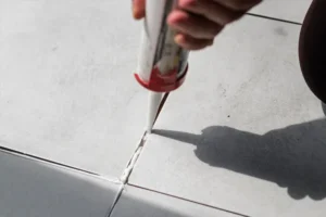 A contractor applying caulk between the concrete slabs