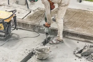A contractor fixing concrete that was affected by concrete settling because of he weather in the area.