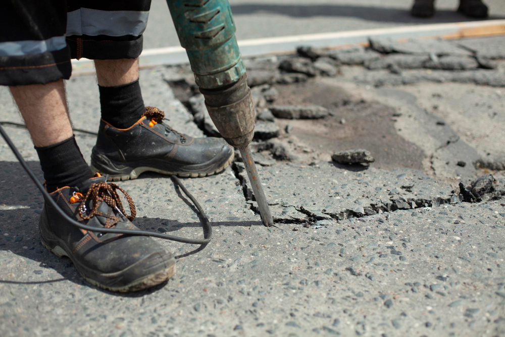 a man working on mudjacking a concrete patch.