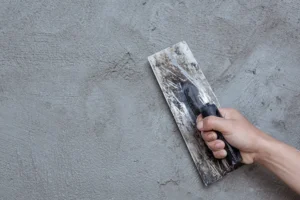 Concrete scaling being repaired on the wall with a trowel